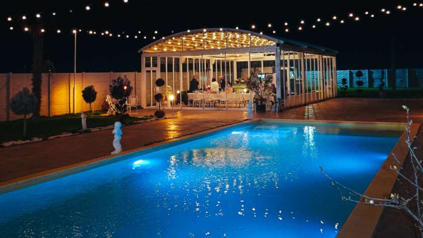 Nuntă elegantă în aer liber cu decorațiuni florale și lumini ambientale la apus de soare, grădină amenajată pentru ceremonie Cernica